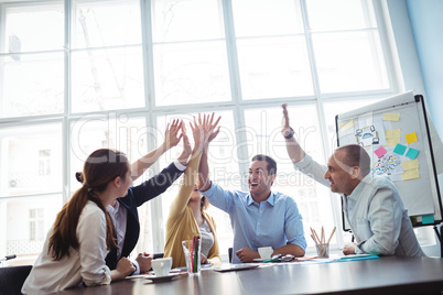 Photo editors high-five in meeting room