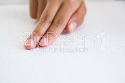 Cropped image of child hand reading braille book