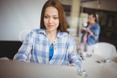 Businesswoman working on laptop at creative office