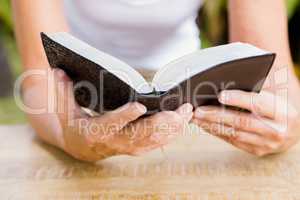 Midsection of woman reading bible