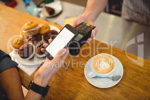 High angle view of customer and barista with technologies at caf