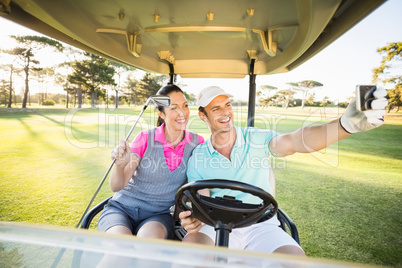 Smiling golfer couple taking self portrait