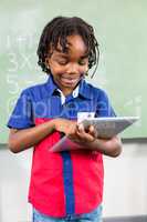 Smiling boy using digital tablet in classroom