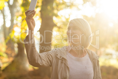 Mature woman smiling while using cellphone