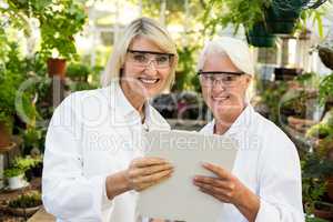 Female colleagues smiling while holding clipboard