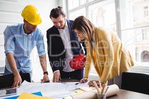 Business people with blueprint on table