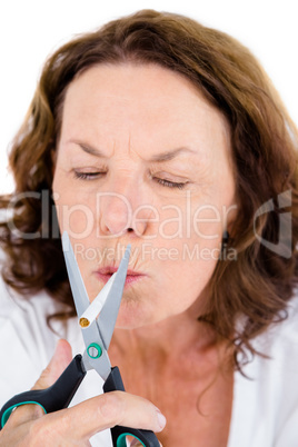 Mature woman cutting cigarette with scissors