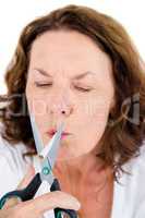 Mature woman cutting cigarette with scissors