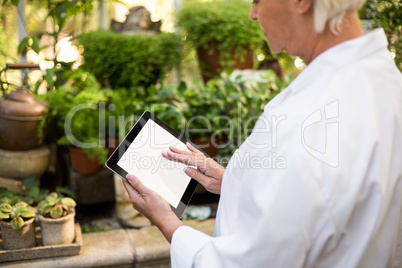 female scientist using tablet computer at greenhouse