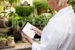 female scientist using tablet computer at greenhouse