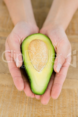 Person holding avocado at table