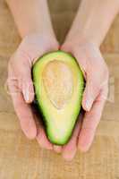 Person holding avocado at table