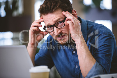 Portrait of executive frowning from headache at office