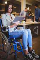 Disabled businesswoman smiling while using digital tablet