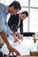 Interior designer discussing blueprint with male coworker