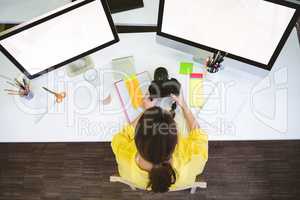 Overhead view of professional sitting with camera at desk in cre