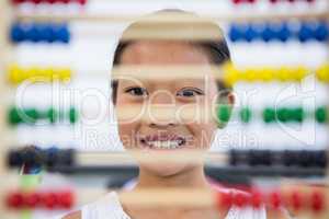 Girl in front of abacus in classroom