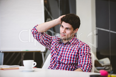 Thoughtful businessman scratching head