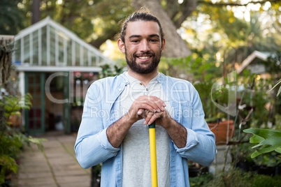Portrait of happy gardener with work tool at garden
