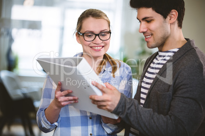 Happy coworkers looking at document at creative office Happy coworkers looking at document at creative office