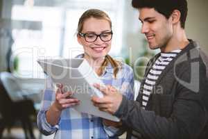 Happy coworkers looking at document at creative office