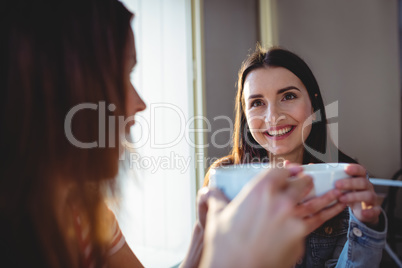 Happy woman with friend at cafeteria