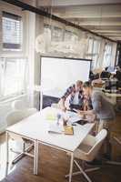 High angle view of colleagues discussing in meeting room