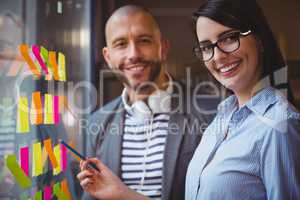 Businesswoman pointing while standing by male colleague