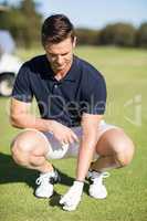 Full length man placing golf ball on tee