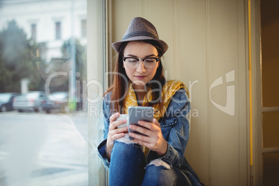 Beautiful woman using cellphone at cafe