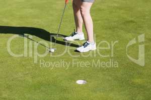 Low section of woman with golf club