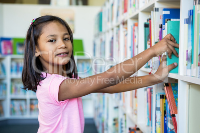 Portrait of girl searching books in school library