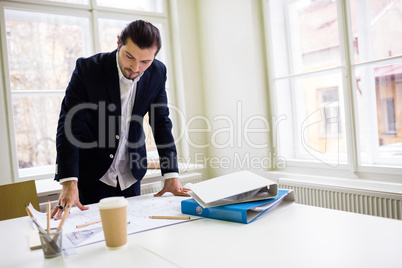 Interior designer looking at blueprint on table