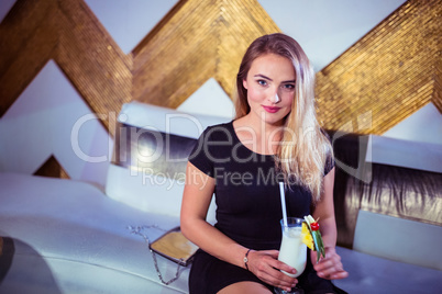 Portrait of woman enjoying drink in nightclub