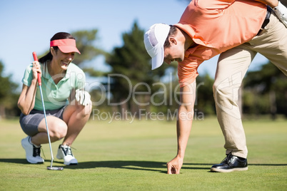 Man removing golf ball from hole