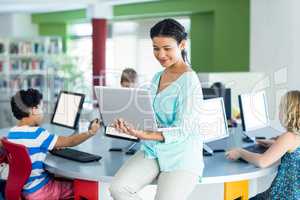 teacher using laptop with computer class