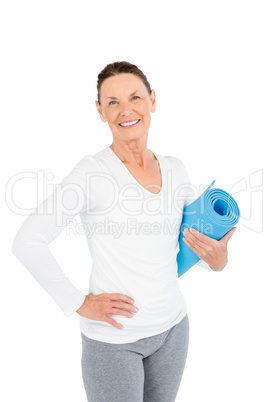 Portrait of smiling mature woman holding exercise mat