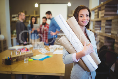 Confident female architect with blueprints