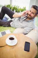 Portrait of businessman using mobile phone at creative office