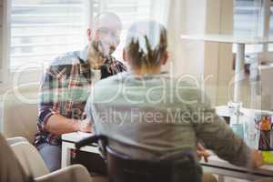 Handicap businessman discussing with colleague in office