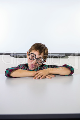 Playful boy making a face in classroom