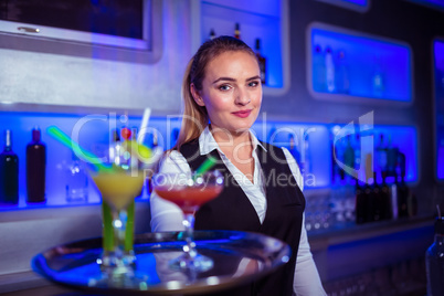 Portrait of confident bartender holding serving tray