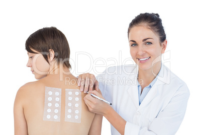 Portrait of smiling doctor examining woman back