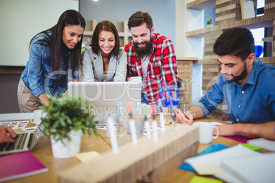 Business people discussing over laptop at desk