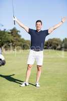 Smiling golfer with arms outstretched