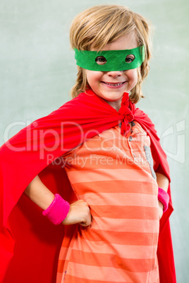 Smiling boy dressed as superhero in classroom