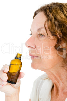 Close-up of thughtful mature woman smelling medicine