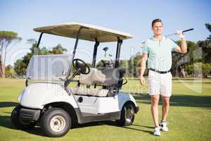 Full length of man standing by golf buggy