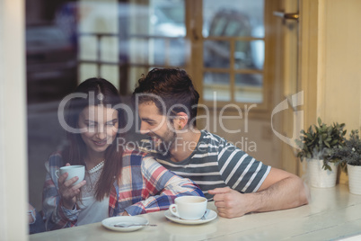 Cheerful couple talking at coffee shop