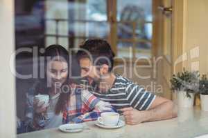 Cheerful couple talking at coffee shop